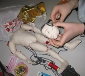 Finishing a puppet's chainmail buzz cut.